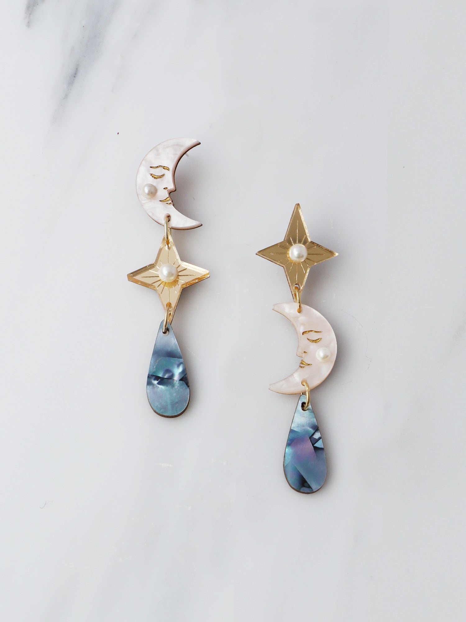 Moon, star and raindrop celestial clip on earrings. Made from acrylic and mother of pearl with sterling silver earring clasps. Handmade in the UK by Wolf & Moon.